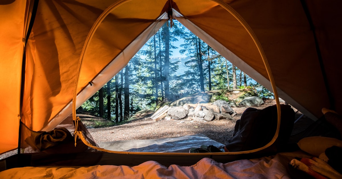 Essential camping gear laid out including tent, sleeping bag, and basic equipment for beginners