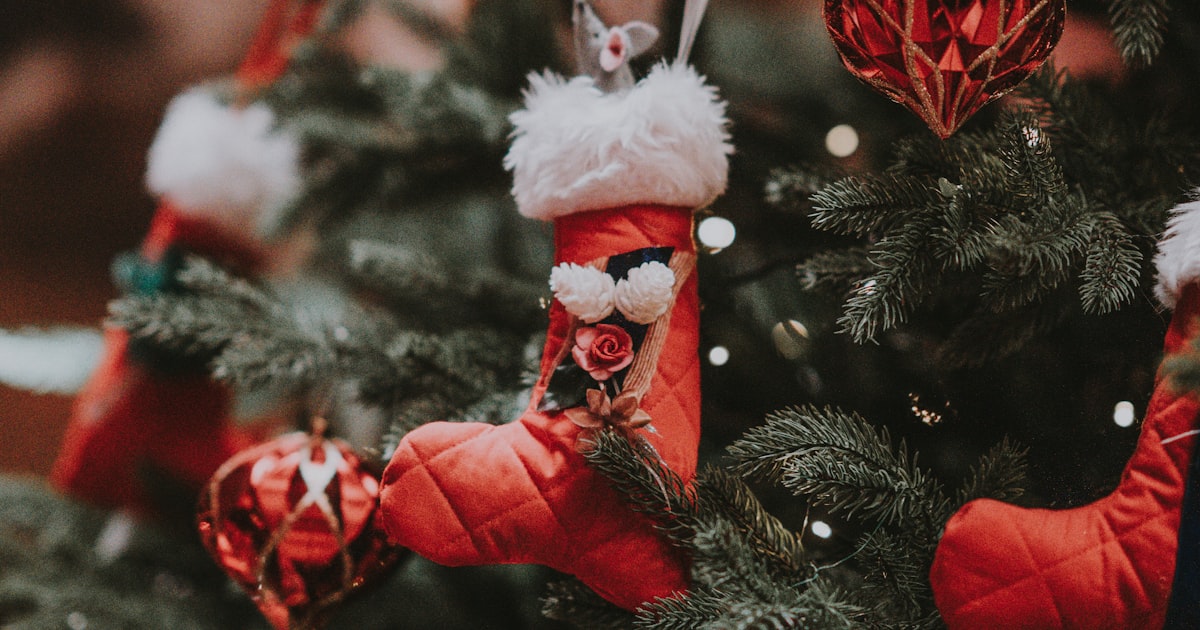 Organized Christmas decorations and gift wrapping supplies laid out neatly on a table with a calendar showing October