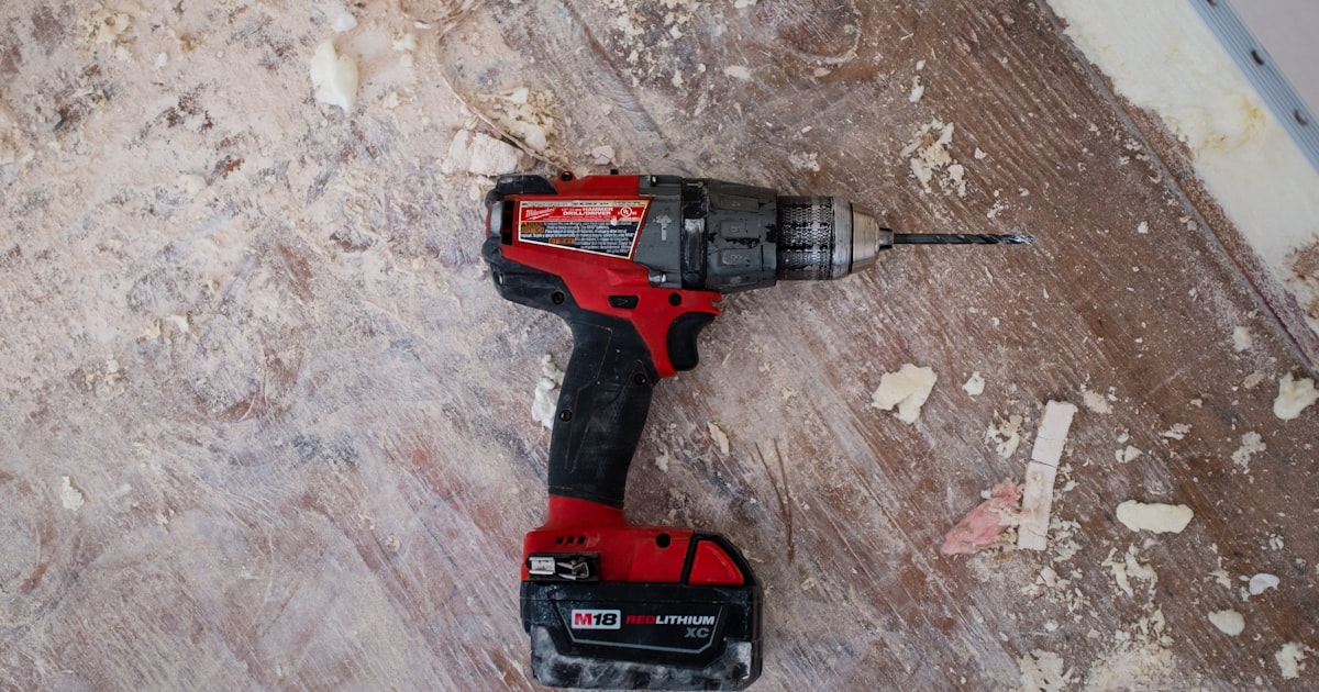 Essential power tools arranged on a workbench including drill, saw, and sander