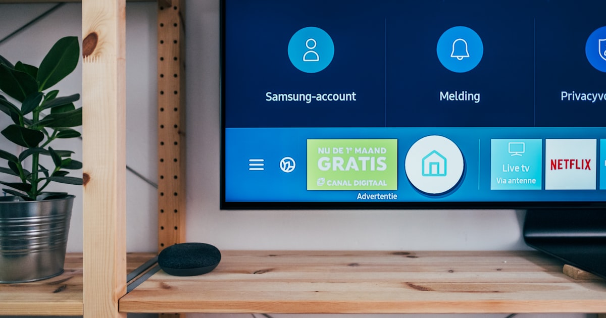 A modern living room with a large TV showing streaming service interfaces and various streaming devices arranged neatly